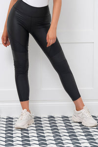Vancouver schwarze Biker Leggins veganes Leder LC76603-2. Leggings bequem und stylisch bei Organza Lingerie online kaufen. Leggings Vorderseite mit Sneakern Bein ausgestellt.